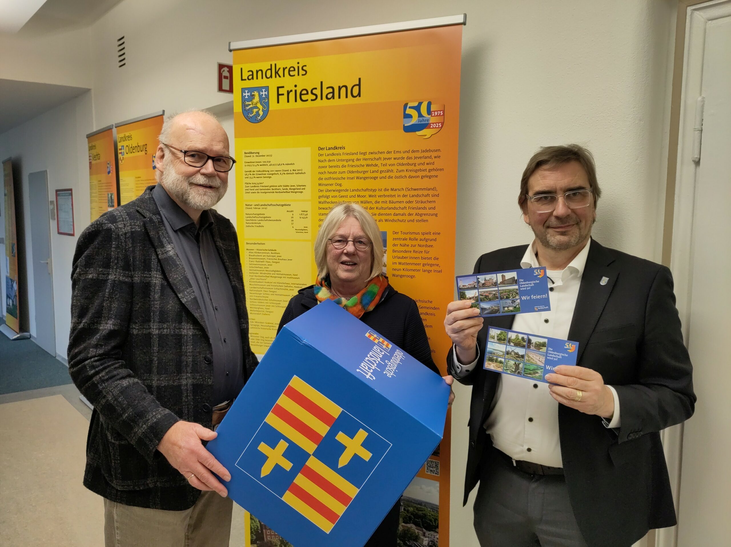 Eröffnung der Wanderausstellung „50 Jahre Oldenburgische Landschaft“ am 8.12.2025 im Kreishaus Jever. v.l.n.r.: Prof. Dr. Uwe Meiners, Präsident Oldenburgische Landschaft; Etta Bengen, Kuratorin; Landrat Sven Ambrosy, Lankreis Friesland.
